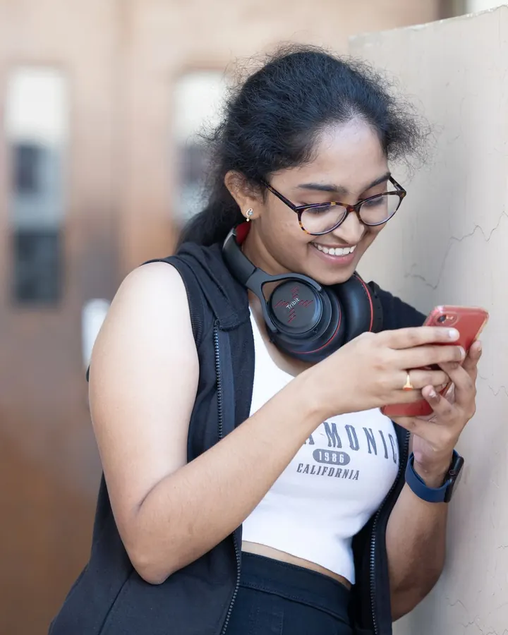 A smiling student taking a quiz on her phone